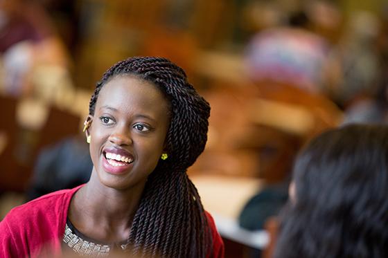 Photo of a young 黑色的 woman smiling in Chatham University's Anderson 餐厅 Hall